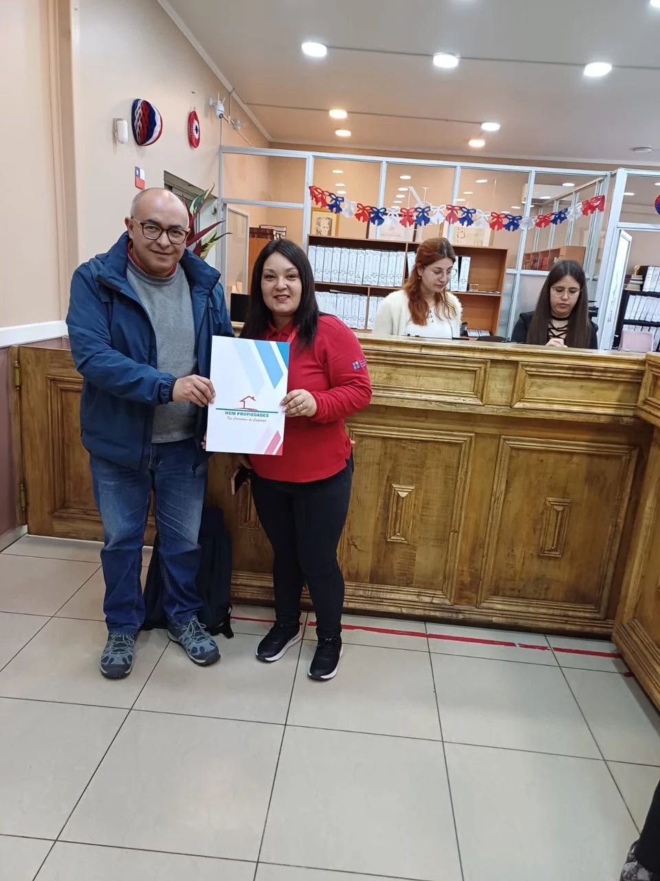 Equipo de Santa Dina entregando una carpeta de postulación a una familia