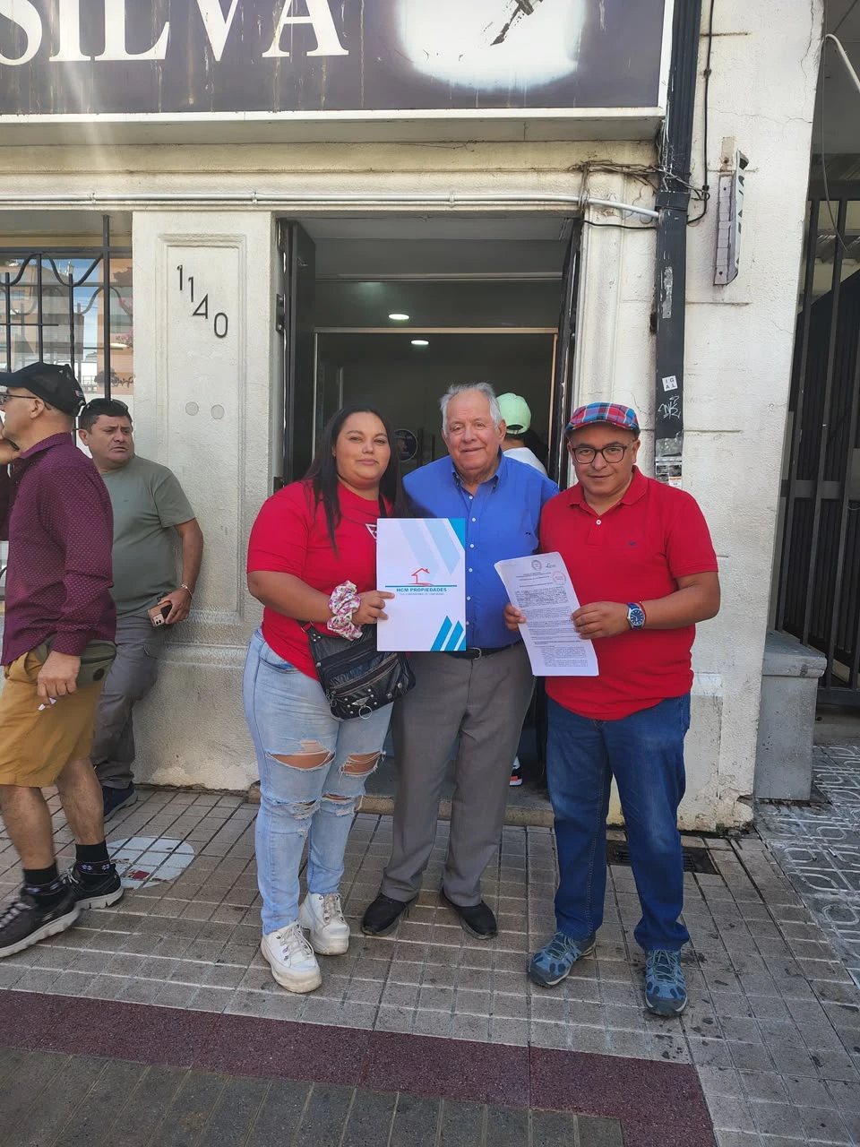 Familias con su documentación de postulación frente a la oficina